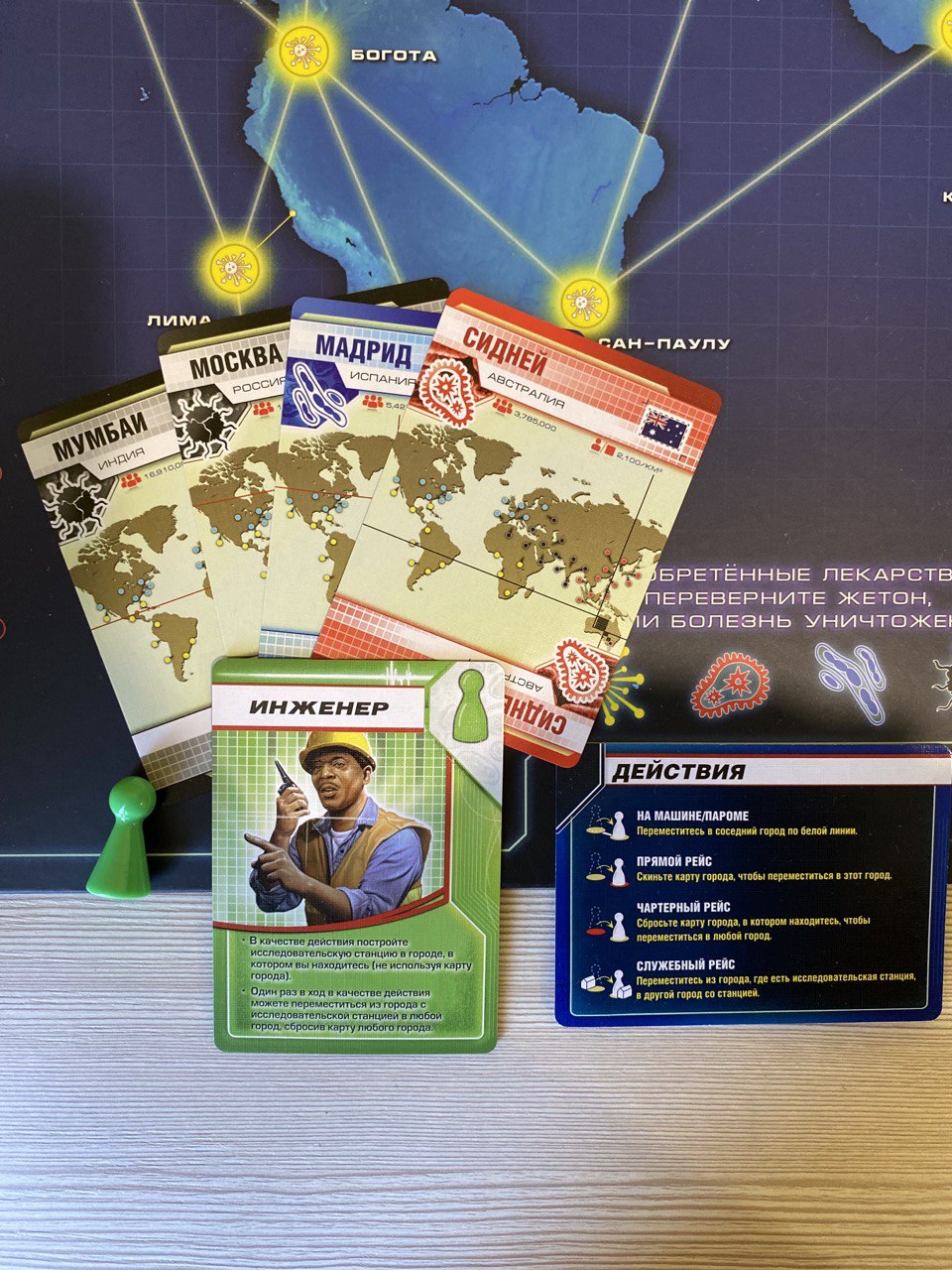 Карточки и игровые фишки в игре Пандемия
